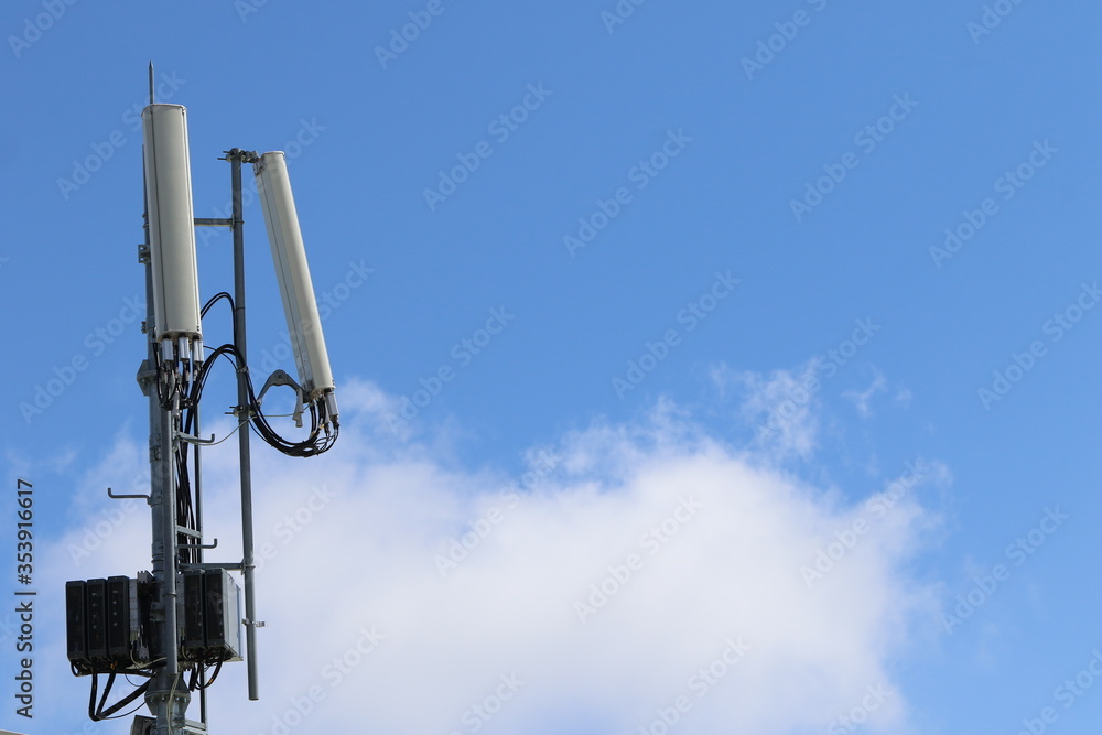 Cellular, mobile phone transmitter tower with blue sky and clouds middle Cellular, mobile phone transmitter tower with blue sky and clouds middle