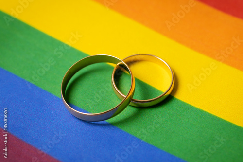 Картината върху платно same-sex marriage concept - two wedding rings on lgbt rainbow flag