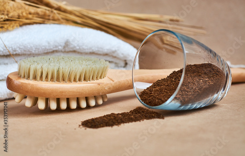 Brush, washcloth for body massage and skin cleaning with natural coffee scrub on beige background. Spa.
