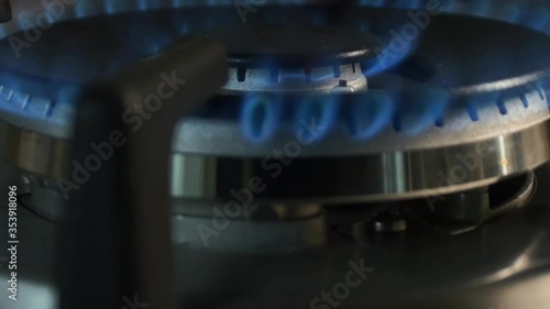 The gas is ignited by a blue flame in the kitchen on a large wok burner. Taken in motion close-up. #1