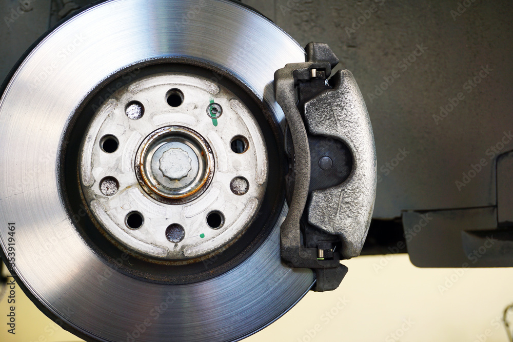 Brake disc, brake caliper mounted on a modern car. Concept of service and car repair. Brake disc, brake caliper mounted on a modern car. Concept of service and car repair.
