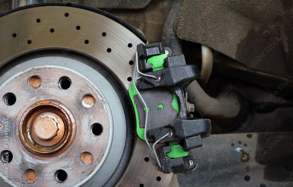 Modern ventilated perforated brake disc mounted on a car. Modern technologies to increase the efficiency of the brake system. Service and repair, spare parts Concept. 
