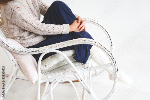 girl in a cozy white vintage chair in a knitted socks and sweater