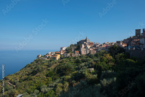 A small hill top town in the afternoon sunshine with the blue sky and ocean and an old fort