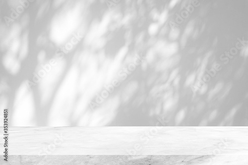 White Marble Table with Tree Shadow on Concrete Wall Texture Background, Suitable for Product Presentation Backdrop, Display, and Mock up. © mesamong