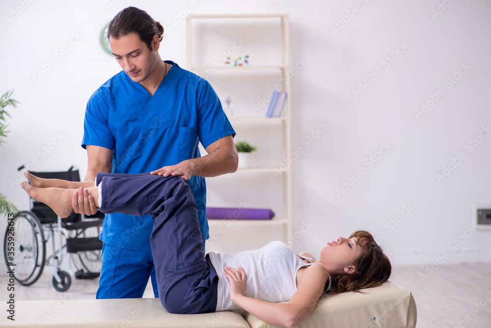 Obraz premium Injured woman visiting young male doctor osteopath