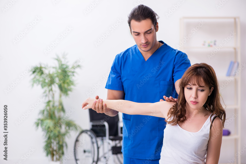 Fototapeta premium Injured woman visiting young male doctor osteopath