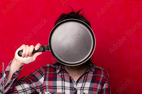 cute woman with a frying pan, red background, red lips, cooking