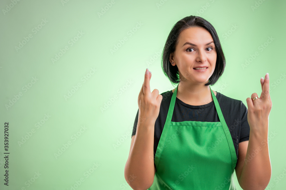Female cook with green apron and black t-shirt showing double good luck Female cook with green apron and black t-shirt showing double good luck