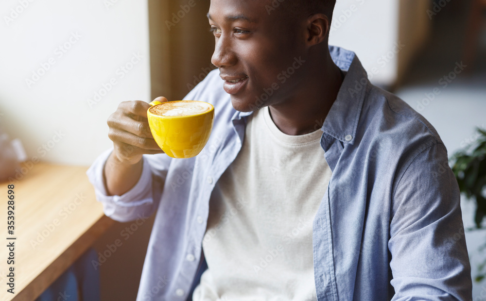 African American man drinking his moring coffee and relaxing in cafe. Panorama African American man drinking his moring coffee and relaxing in cafe. Panorama