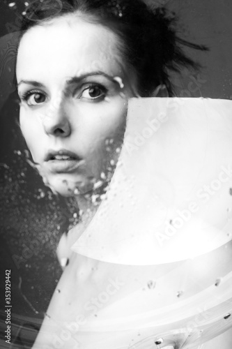 beautiful young brunette girl portrait under a glass of water