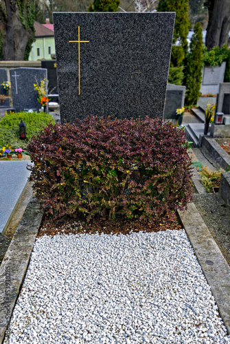 grave with granite tombstone and covered by white stones
