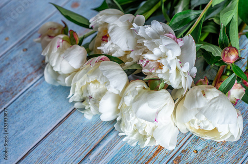  bouquet of white fresh peonies on a blue wooden background © Анна Яблоновская