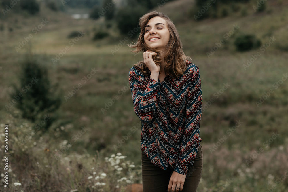 Happy woman standing in nature and smiling Happy woman standing in nature and smiling