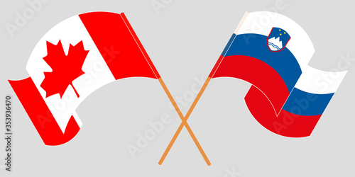 Crossed and waving flags of Slovenia and Canada