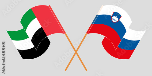 Crossed and waving flags of Slovenia and the United Arab Emirates