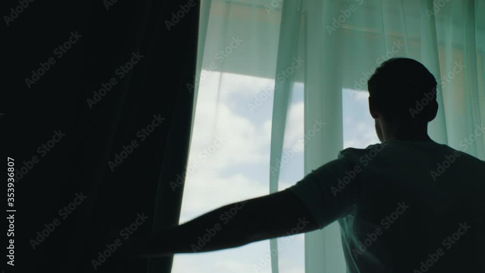 man opens the blackout curtains man opens the blackout curtains