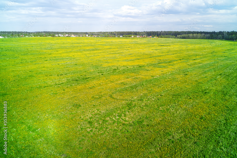 Obraz premium Green field and village on the horizon aerial