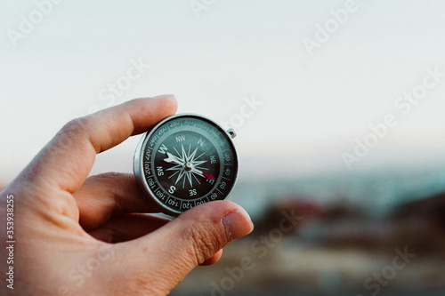 hands holding a compass ,a view of a city and 