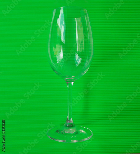 Glass for serving wine on a green background