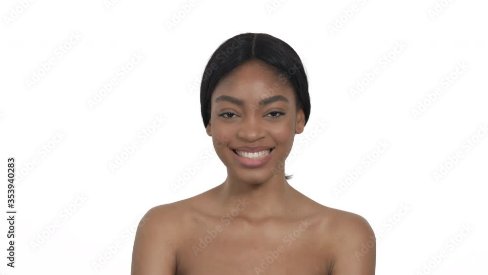 Attractive young woman with tight brunette hair posing to camera. African model is smiling widely. Isolated, on white background Attractive young woman with tight brunette hair posing to camera. African model is smiling widely. Isolated, on white background