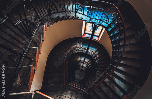 Destroyed spiral staircase indoors. Natural light. Beautiful architecture. Old apartment building in Saint Petersburg. Winding stair. Devastated ruins