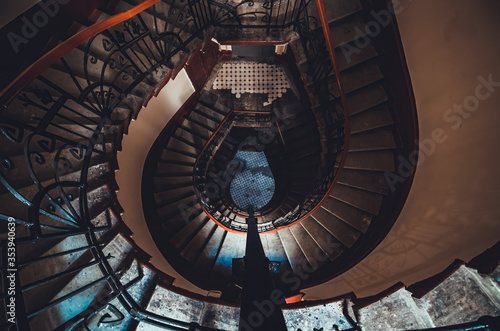 Destroyed spiral staircase indoors. Natural light. Beautiful architecture. Old apartment building in Saint Petersburg. Winding stair. Devastated ruins