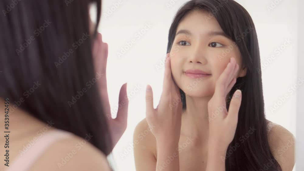 Beautiful asian woman look face in mirror for skin care with cream. Beautiful asian woman look face in mirror for skin care with cream.