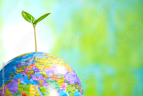 sprout on the globe on a green background, updating the planet, protecting the earth