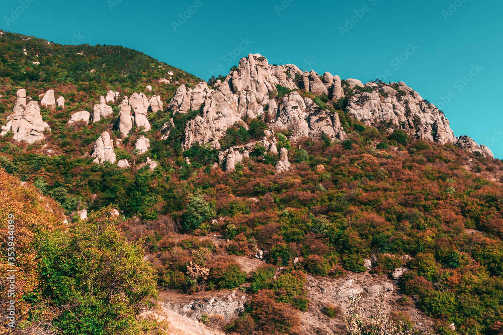Mountain bottom of Mount Demerdzhi, view of the Valley of Ghosts at sunset. Natural sight of Crimea. Geological limestone weathering. Erosion of rocks. Amazing rocky landscape with blue sky