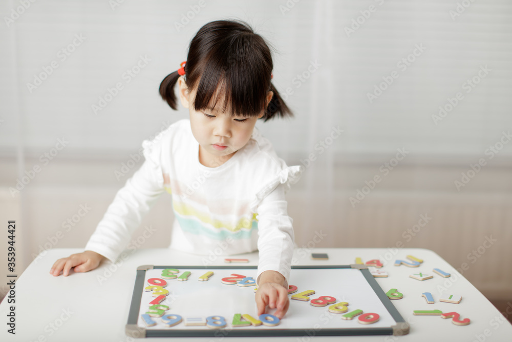 toddler girl learning math on white board against white background toddler girl learning math on white board against white background
