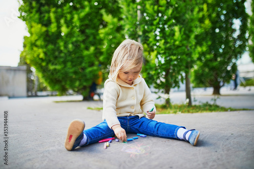 Adorable toddler girl drawing with colorful chalks © Ekaterina Pokrovsky