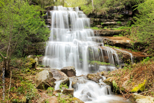 Silky water streams and cascades of powerful, sunlit Tupavica waterfall on Old mountain at late spring