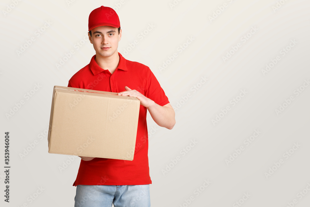 Modern package delivery to door. Courier in uniform holds big box Modern package delivery to door. Courier in uniform holds big box