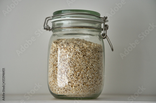  Glass jars with a lid for food on a white shelf. Storage in the kitchen. Containers with bulk products. Transparent container.