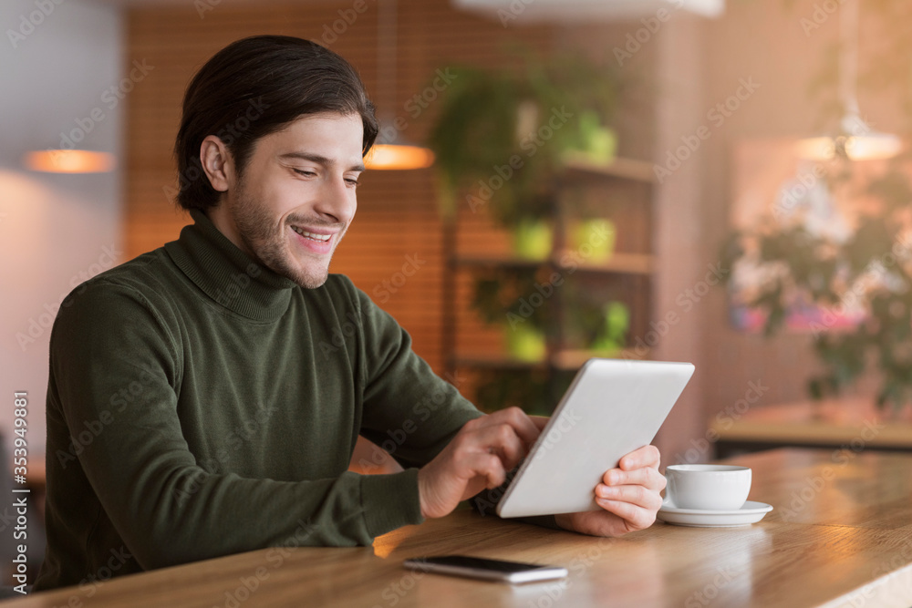 Joyful businessman reading news on digital tablet at cafe Joyful businessman reading news on digital tablet at cafe