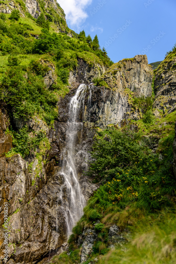 Obraz premium Beautiful waterfall on a summer day from Fagaras Mountains, Romania