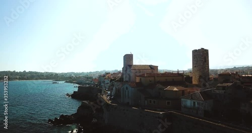 Aerial footage of Antibes, France, Cote D Azur. Beautiful sunny day in Mediterranean Sea. Old castle and sea. Roofs and beach. photo