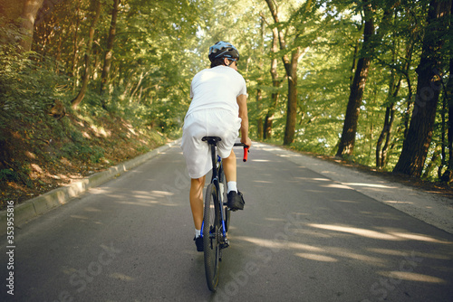 Man with a bike. Sportsman in a forest. Morning bike ride. © hetmanstock2