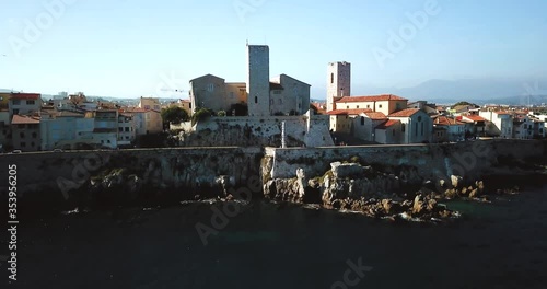 Aerial footage of Antibes, France, Cote D Azur. Beautiful sunny day in Mediterranean Sea. Old castle and sea. Roofs and beach. photo