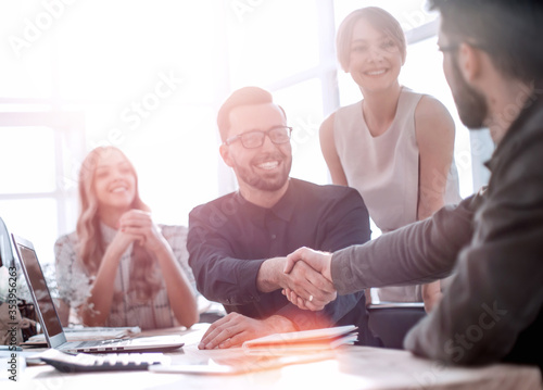 background image of the handshake of business partners in the office