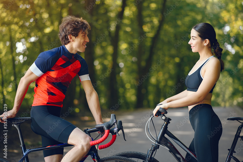 Obraz premium People with a bikes. Couple in a forest. Morning bike ride.