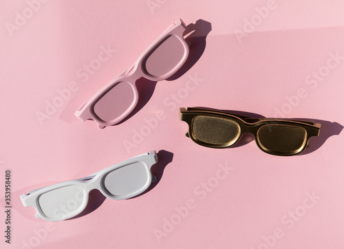 Colored sunglasses from the sun on a pink background. Creative concept.