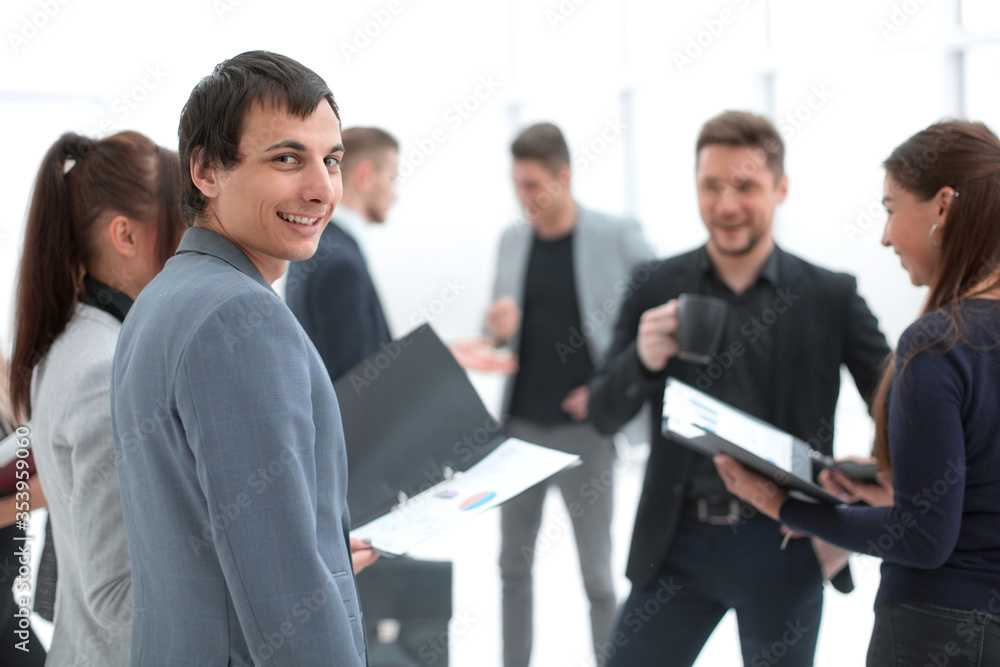 group of employees discussing business documents standing in the office group of employees discussing business documents standing in the office