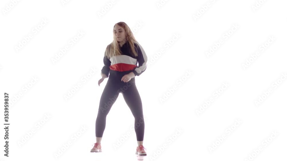 Attractive female modern style dancer performing in the studio. Hip hop street dance on a stage in front of the spotlight. Isolated. Contemporary choreography. Long shot Attractive female modern style dancer performing in the studio. Hip hop street dance on a stage in front of the spotlight. Isolated. Contemporary choreography. Long shot