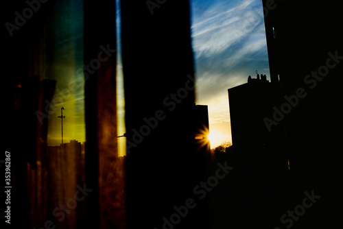 Sunset view from the window of a building, warm and melancholic atmosphere with cloud background. © Joaquin Corbalan