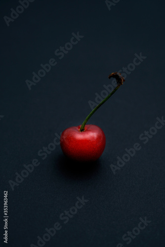 A fresh cherry placed on a black background photo