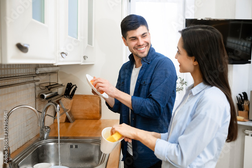 Obraz na plátně Portrait of young lovely couple washing dishes