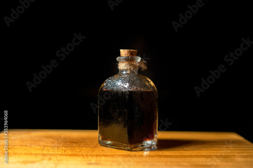 bottle of coffee liquor on wood in black background