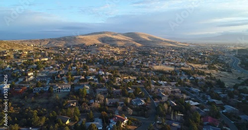 Spectacular aerial view of upscale neighborhood in Prescott Valley, Arizona at sunrise with cinematic camera spin over homes and streets. photo